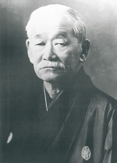 Black-and-white portrait of Jigoro Kano, the founder of judo, in a dark kimono